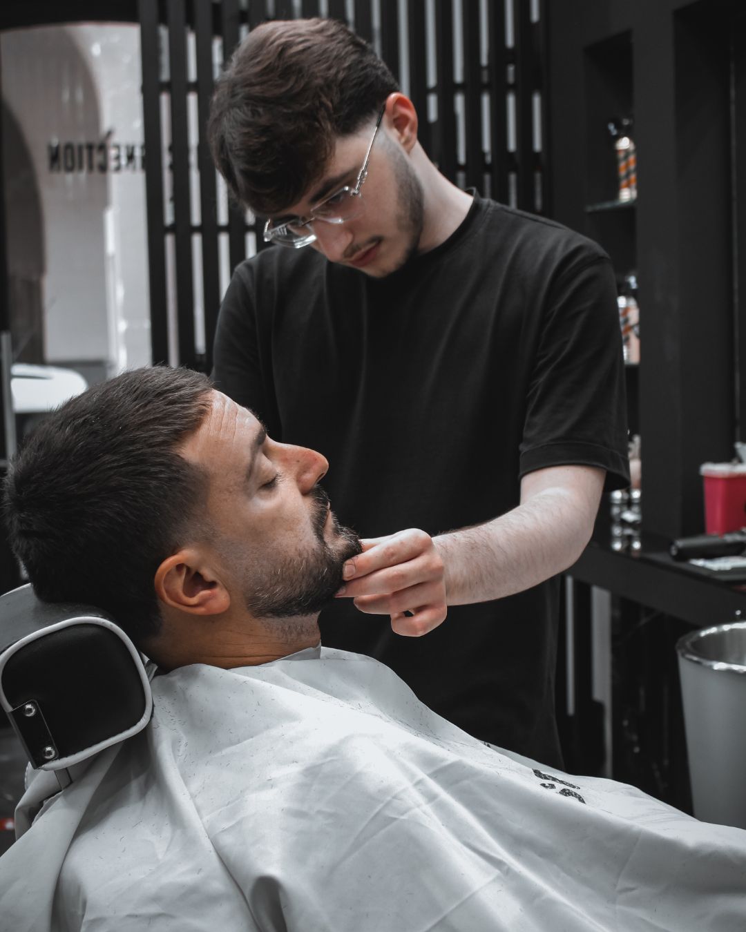 Un barbiere rifinisce la barba di un cliente