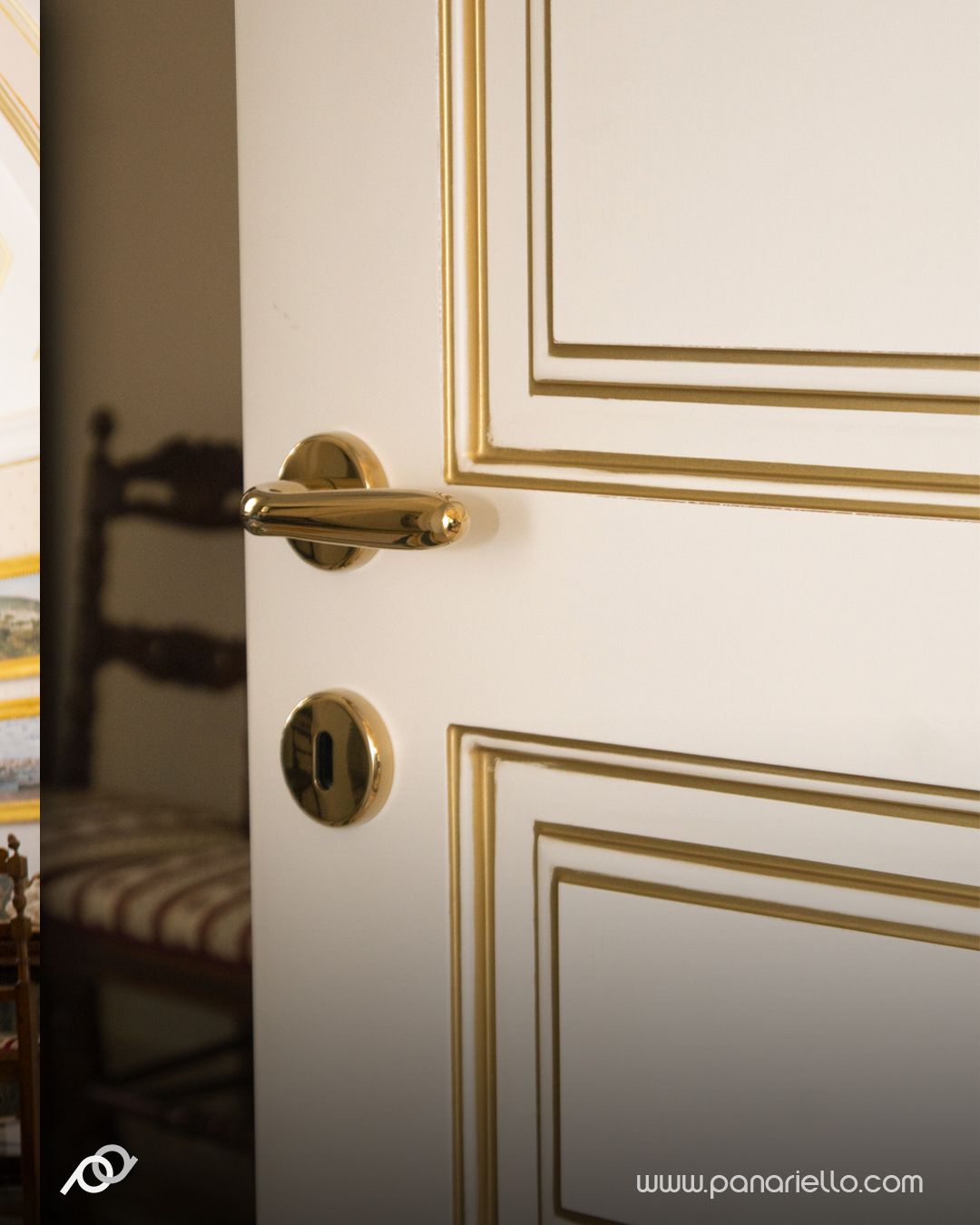 Porta bianca con profili oro e maniglia in ottone